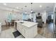 Modern kitchen featuring a large island, stainless steel appliances, and dining area at 124 Juno Dr, Groveland, FL 34736