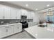 Modern kitchen featuring white cabinets, stainless steel appliances, and a large island at 124 Juno Dr, Groveland, FL 34736