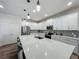 Bright kitchen with white cabinets, stainless steel appliances, and a large center island with bar seating at 124 Juno Dr, Groveland, FL 34736