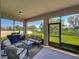 Screened-in patio with comfortable seating, a grill, and a scenic view of the backyard at 124 Juno Dr, Groveland, FL 34736