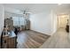 Bright living room featuring wood-look floors, ceiling fan, and a large window at 124 Juno Dr, Groveland, FL 34736