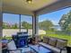 Cozy screened patio featuring comfortable seating and a grill for outdoor relaxation at 124 Juno Dr, Groveland, FL 34736