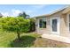 Backyard view with a small patio and door, complemented by green space and landscaping at 1282 Fort Lawn Loop, The Villages, FL 32162