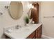 Bathroom with double sinks, dark cabinets, round mirrors, chrome fixtures, and accent lighting at 1282 Fort Lawn Loop, The Villages, FL 32162