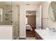 Bathroom with glass shower, ceramic tile, double vanity, and a door to the main bedroom at 1282 Fort Lawn Loop, The Villages, FL 32162