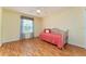 Bedroom with hardwood floors, ceiling fan, daybed, and lots of natural light from the window at 1282 Fort Lawn Loop, The Villages, FL 32162