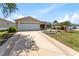 Charming single-story home featuring a well-maintained lawn, landscaped flower beds, and a two-car garage at 1282 Fort Lawn Loop, The Villages, FL 32162