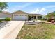 Charming single-story home showcasing a well-maintained lawn, complemented by manicured flower beds at 1282 Fort Lawn Loop, The Villages, FL 32162
