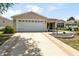 Charming single-story home featuring a well-maintained lawn, landscaped flower beds, and a two-car garage at 1282 Fort Lawn Loop, The Villages, FL 32162