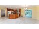 Spacious kitchen with tile floors, wood cabinets, island, and a view to a bright adjacent room at 1282 Fort Lawn Loop, The Villages, FL 32162