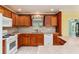 Updated kitchen with granite countertops, wood cabinets, tile backsplash, and modern appliances at 1282 Fort Lawn Loop, The Villages, FL 32162
