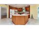 Well-lit kitchen with wood cabinets, island, and white appliances in a cozy setting at 1282 Fort Lawn Loop, The Villages, FL 32162