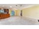 Bright living room with neutral tile flooring, skylights, open layout, and views into the kitchen and dining area at 1282 Fort Lawn Loop, The Villages, FL 32162