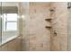 Shower stall featuring glass partition, ceramic tile surround, two shelves, and a shower caddy at 1282 Fort Lawn Loop, The Villages, FL 32162
