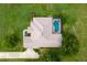 Aerial view of home and property featuring manicured yard, pool, patio and long driveway at 12913 County Road 104B, Oxford, FL 34484