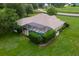 Aerial view showcases backyard oasis with screened-in pool and lush, landscaped surroundings at 12913 County Road 104B, Oxford, FL 34484