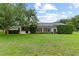 Expansive backyard with lush green grass and mature trees providing privacy and shade at 12913 County Road 104B, Oxford, FL 34484