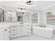 Modern bathroom with soaking tub, dual sinks, and sleek black fixtures at 12913 County Road 104B, Oxford, FL 34484