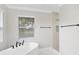 Luxurious bathroom featuring a soaking tub, walk-in shower, and modern fixtures at 12913 County Road 104B, Oxford, FL 34484