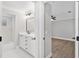 Bathroom featuring a white vanity, modern mirror and fixtures, shower and view to the main bedroom at 12913 County Road 104B, Oxford, FL 34484