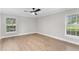 Spacious bedroom with wood-look floors and two windows providing natural light at 12913 County Road 104B, Oxford, FL 34484