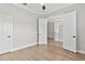 A bright bedroom featuring hardwood floors, a ceiling fan, and two closets at 12913 County Road 104B, Oxford, FL 34484