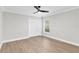 Bedroom featuring light wood floors, neutral walls, a ceiling fan, and a closet at 12913 County Road 104B, Oxford, FL 34484