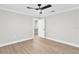Bright bedroom featuring laminate wood flooring, neutral colored walls, and a ceiling fan at 12913 County Road 104B, Oxford, FL 34484