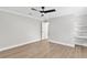Spacious bedroom with wood laminate floors, neutral walls, white trim, and a ceiling fan at 12913 County Road 104B, Oxford, FL 34484
