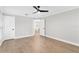 Bedroom featuring modern ceiling fan, wood-look floors, and multiple doors for easy access at 12913 County Road 104B, Oxford, FL 34484