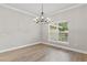Bright dining room features modern chandelier, beautiful wood-look floors, large window, and neutral paint at 12913 County Road 104B, Oxford, FL 34484