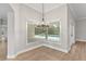 Bright dining area with backyard pool views, wood flooring, modern lighting and neutral paint at 12913 County Road 104B, Oxford, FL 34484