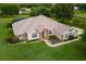 Landscaped home featuring a stone entryway and an enclosed screened pool area at 12913 County Road 104B, Oxford, FL 34484