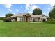 Charming single-story home with stone accents, manicured lawn, and lush landscaping at 12913 County Road 104B, Oxford, FL 34484