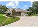 Well-maintained home with a two-car garage, lush landscaping, and a charming exterior at 12913 County Road 104B, Oxford, FL 34484