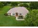 Well-kept home showcasing stone accents, a manicured lawn, and a screened-in pool at 12913 County Road 104B, Oxford, FL 34484
