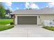 Spacious two-car garage with a large driveway and well-maintained landscaping at 12913 County Road 104B, Oxford, FL 34484