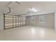 Spacious two car garage with windows, white painted walls, and epoxy flooring at 12913 County Road 104B, Oxford, FL 34484