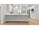 Open-concept kitchen features stainless appliances, island with seating, modern lighting, and neutral paint at 12913 County Road 104B, Oxford, FL 34484
