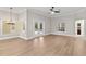 Bright living room with wood flooring, crown molding and French doors leading to outdoor pool at 12913 County Road 104B, Oxford, FL 34484
