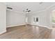 Spacious living room featuring hardwood floors, neutral paint, and a ceiling fan at 12913 County Road 104B, Oxford, FL 34484