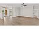 Spacious living room with wood flooring, ceiling fan, crown moulding, and lots of natural light from the front door and side windows at 12913 County Road 104B, Oxford, FL 34484