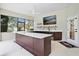Covered outdoor kitchen and bar with a white countertop and TV at 12913 County Road 104B, Oxford, FL 34484