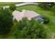 View of the screened-in pool area surrounded by lush greenery and mature trees at 12913 County Road 104B, Oxford, FL 34484
