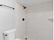 Shower featuring white tile, black fixtures, a built-in niche, and pebble floor at 12913 County Road 104B, Oxford, FL 34484