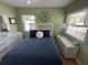 Green bedroom featuring a bed with blue bedding, ceiling fan, and dresser at 1339 Orchid Ave, Winter Park, FL 32789