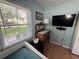 Bright bedroom with wood floors, daybed, a dresser and a flat screen television at 1339 Orchid Ave, Winter Park, FL 32789