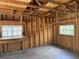 Unfinished garage space showing wood framing, a workbench, concrete flooring, and natural light from two windows at 1339 Orchid Ave, Winter Park, FL 32789