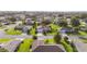Wide aerial of a home in a well-kept neighborhood with manicured lawns and mature trees at 13643 Se 89Th Ct, Summerfield, FL 34491