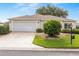 Charming single-story home featuring a well-maintained lawn and attached two-car garage at 13643 Se 89Th Ct, Summerfield, FL 34491